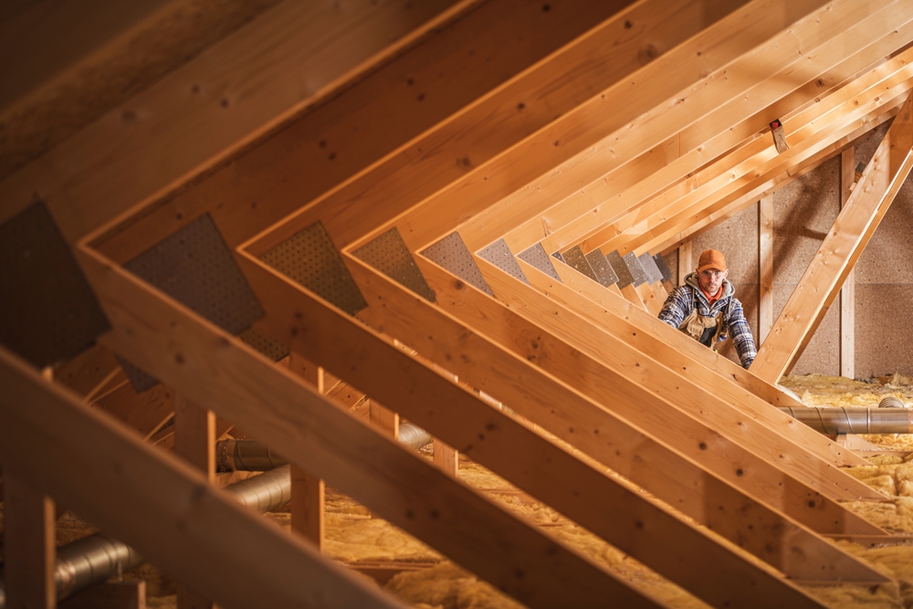 The Truth About Noise in Modular Homes (It's Not What You Think) 2 A,Construction,Worker,Checks,Insulation,Materials,In,A,Wooden,Attic representing insulation of Evermod modular homes